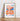 Almanac Co Prints poster featuring 'Aperol Spritz' in bold orange and blue typography with a drink illustration, framed and leaning on a wooden floor