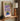 Green and purple version of Almanac Co Prints poster on a wooden shelf, with warm light and modern accessories nearby.