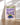 Framed “This Is My Happy Place” poster by Almanac Co Prints with green, purple and blue figure, leaning on wooden floor with soft light.