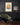 Almanac Co Prints artwork with warm orange tones in dark moody lounge with green armchair and modern mid-century style.
